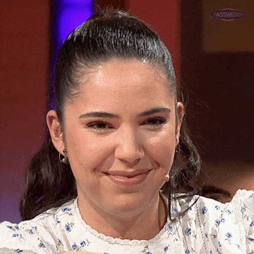a woman with a ponytail is smiling in front of a red background that says passwisdom
