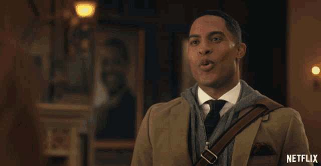 a man in a suit and tie is laughing with the netflix logo in the corner