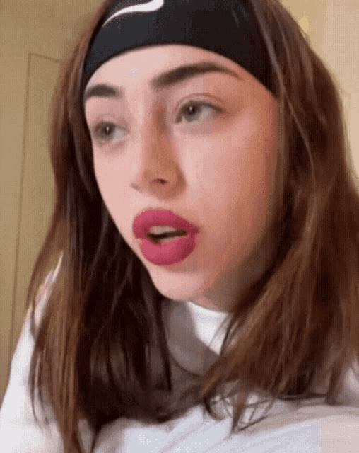 a young woman wearing a headband with the nike logo on it