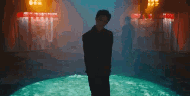 a man is standing in the middle of a pool of water in a dark room .