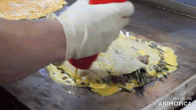 a person is cooking food on a griddle and the griddle is made in animonica