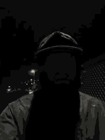 a man with a beard is wearing a hat and sunglasses