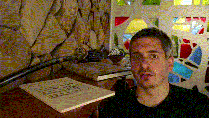 a man sitting in front of a stained glass window with a book on the table that says ' samurai ' on it