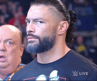 a man with a beard is wearing a t-shirt that says w live on it