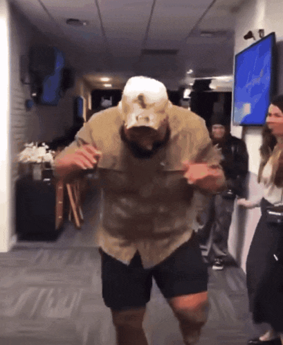 a man in a tan shirt and shorts is dancing