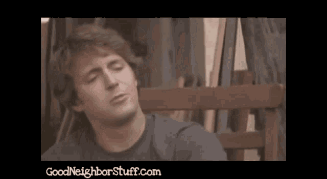 a man sits on a bench with his eyes closed and the website goodneighborstuff.com is below him