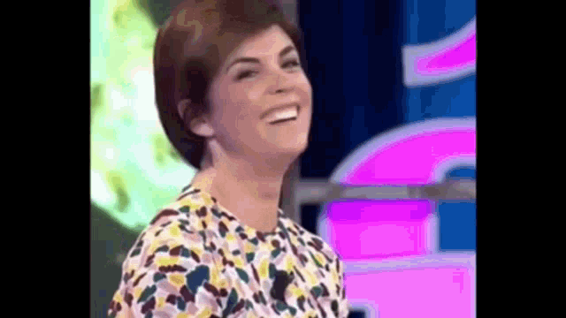a woman is smiling and laughing on a stage .