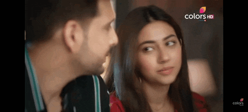 a man and a woman are looking at each other and the woman is smiling .