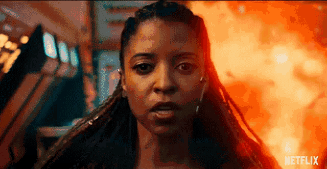 a close up of a woman 's face in front of a fire with the word netflix on the bottom .