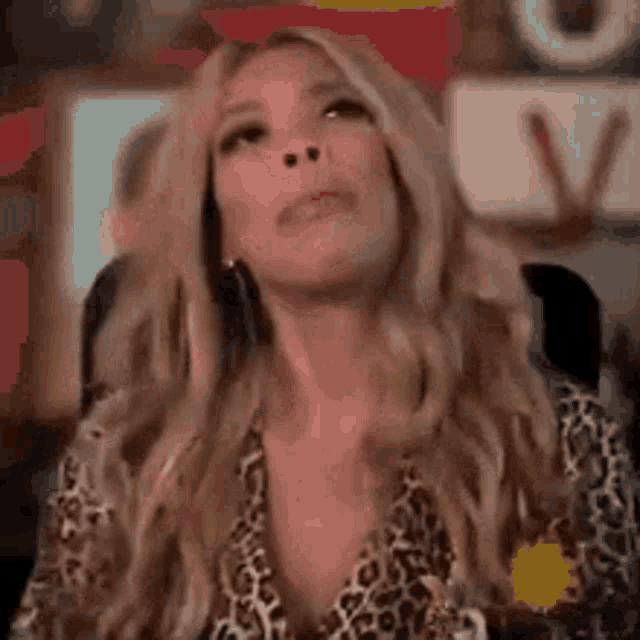 a woman in a leopard print shirt is sitting in a chair .