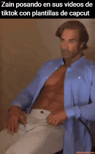 a shirtless man in a blue shirt is sitting down