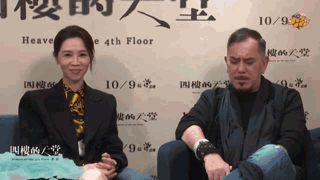 a man and a woman are sitting in front of a wall that says heaven on the 4th floor