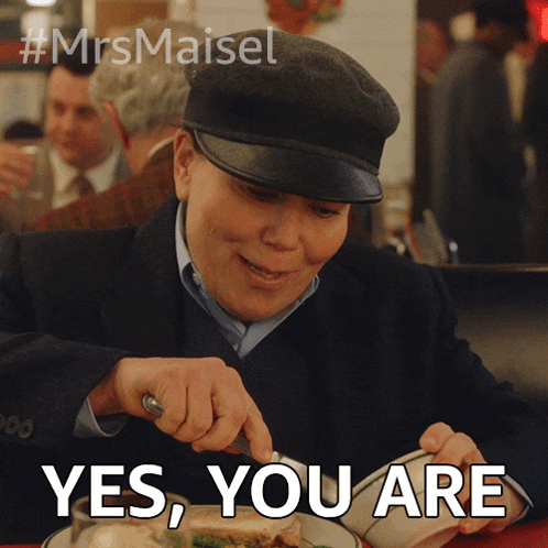 a woman wearing a hat is sitting at a table with a plate of food and the words yes you are above her