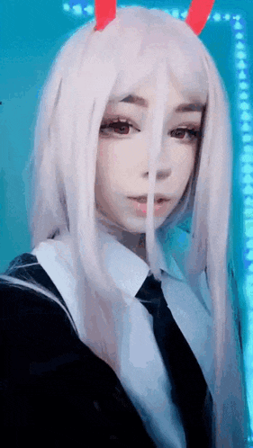 a girl with long white hair and red horns is taking a selfie