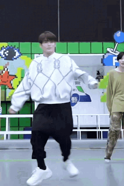 a man is dancing in front of a sign that says f on it