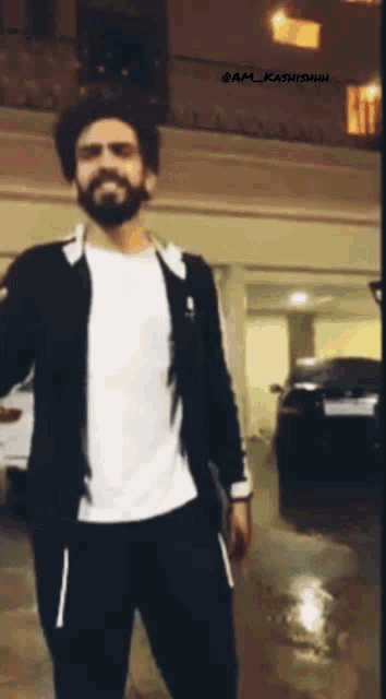 a man with a beard is standing in a parking garage