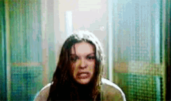 a woman with long hair is making a funny face and looking at the camera .