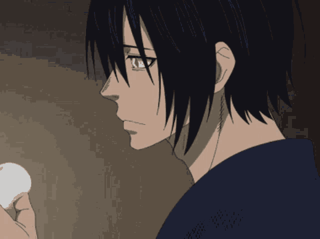 a man with long black hair is holding a white object in his hand