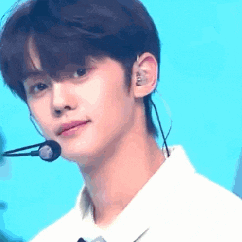 a close up of a young man wearing a microphone and headphones .