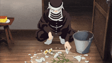 a man in a mask is kneeling on the floor with a bucket