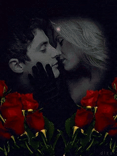 a man and a woman are kissing in front of roses