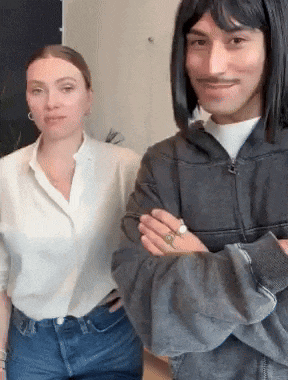 a man and a woman are posing for a picture with their arms crossed .