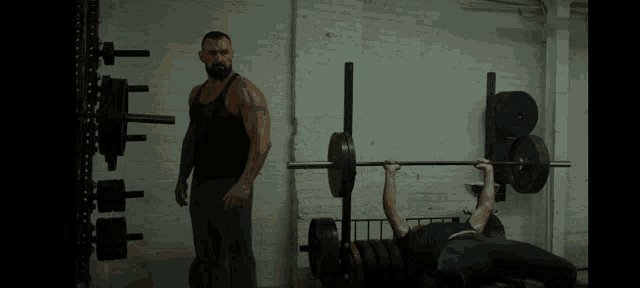 a man with a beard is standing in a gym