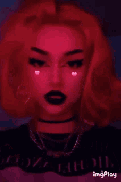 a girl with red hair and black lipstick is wearing a choker .