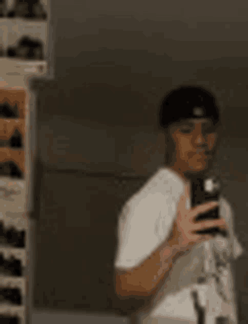 a man is taking a selfie in front of a mirror with his cell phone .