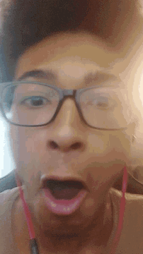 a close up of a person wearing glasses and pink headphones