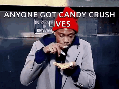 a man in a red hat is eating a piece of bread with the words " anyone got candy crush " above him