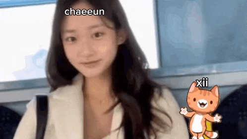 a girl with long hair is sitting next to a cartoon cat with the words chaeeun and xii written on it .