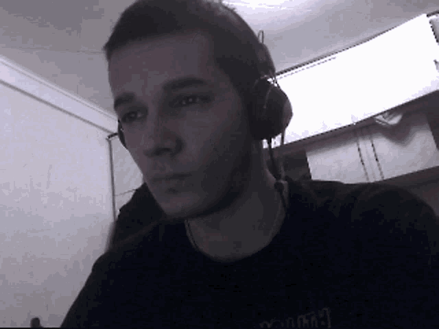 a young man wearing headphones and a black shirt that says ' thrasher '
