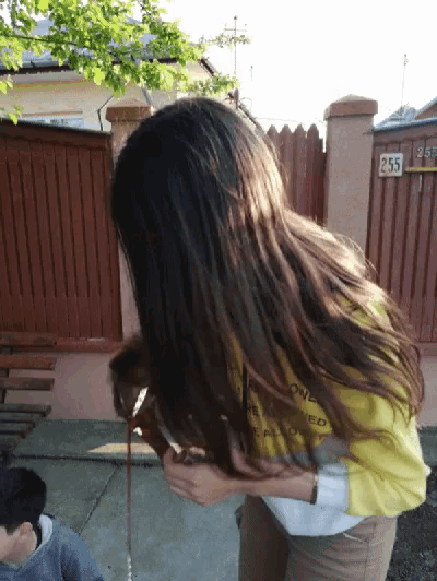 a girl wearing a yellow shirt that says " one more time " is holding a dog