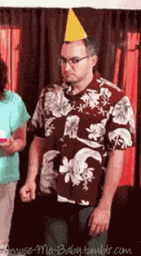a man wearing a party hat is standing in front of a woman