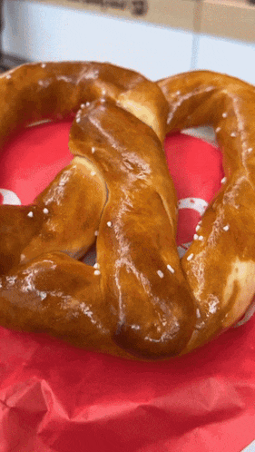 a pretzel is sitting on a red napkin with a white s on it