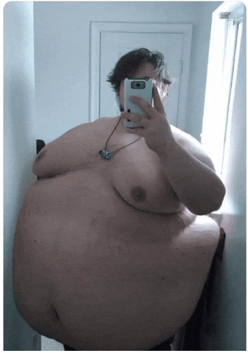 a very large man taking a selfie with a cell phone
