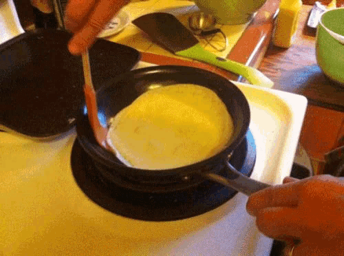a person is cooking food in a pan on a stove