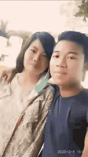 a man and a woman are posing for a selfie .