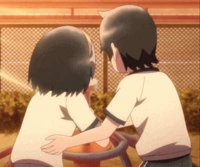 a boy and a girl are hugging in a park