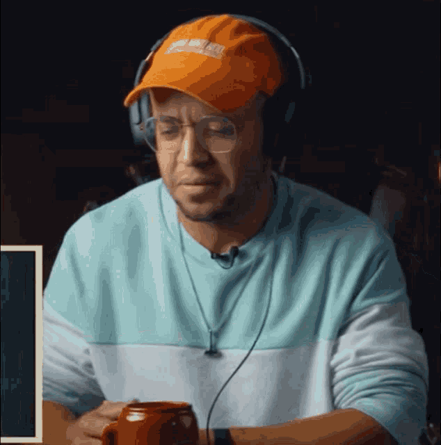 a man wearing headphones and an orange hat that says ' united states of america ' on it