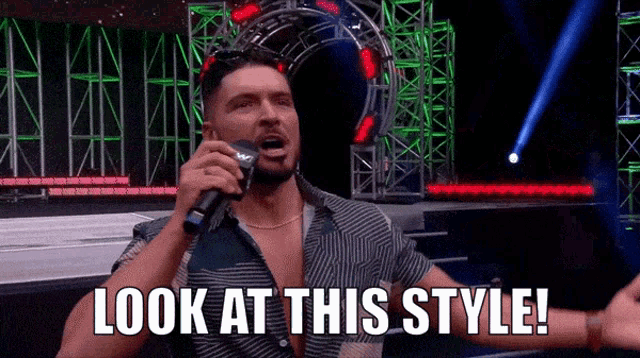 a man is holding a microphone and saying look at this style .