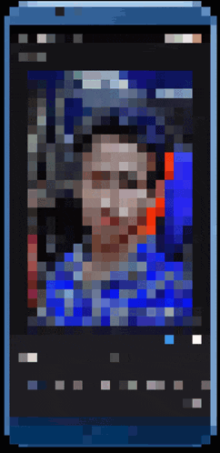 a pixelated image of a man 's face with a blue shirt on