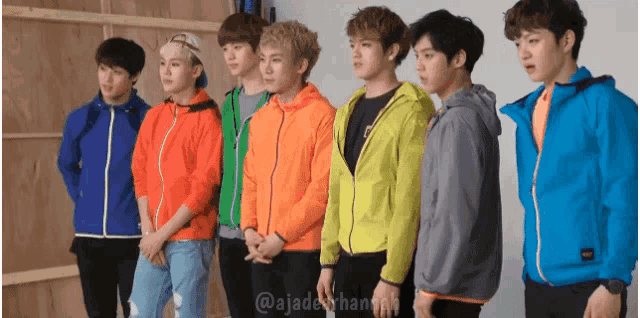 a group of young men are standing next to each other with their hands folded