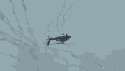 a helicopter is flying through a cloudy sky in a slow motion .