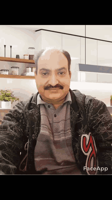 a man with a mustache is wearing a black jacket with a s on it