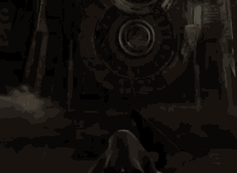 a person in a hooded cape with red eyes is standing in front of a large wheel .