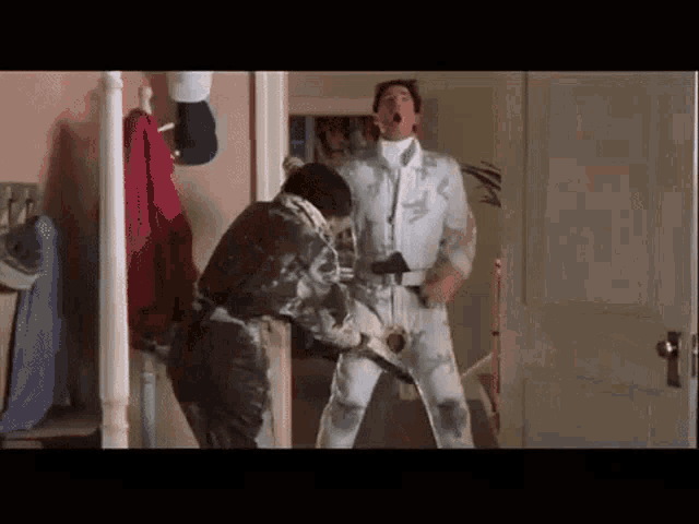 two men are standing next to each other in a room .