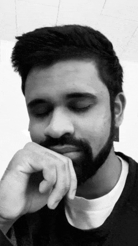 a black and white photo of a man with his hand on his chin