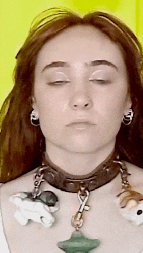 a close up of a woman wearing a choker and earrings with her eyes closed